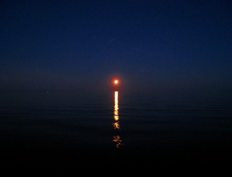 The full moon sets over Lake Michigan on August 16, 2008