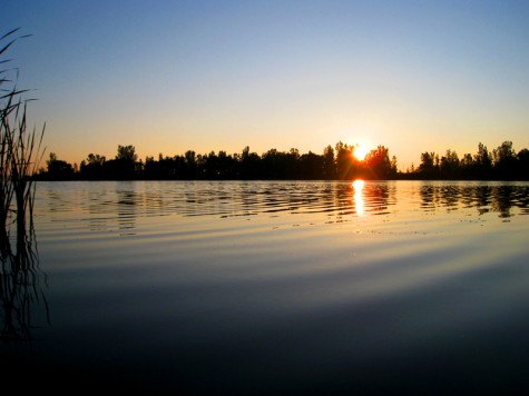 The sun rise over Muskegon Lake behind the Michigan Steel plant.