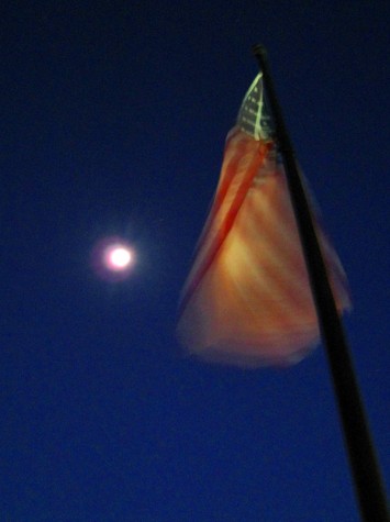 The moon illuminates the waving flag outside of the Parmenter building in downtown Muskegon.