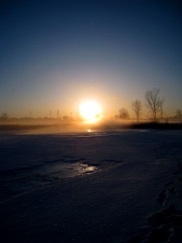The sunrise through the morning fog across an icy Muskegon Lake on February 19, 2010